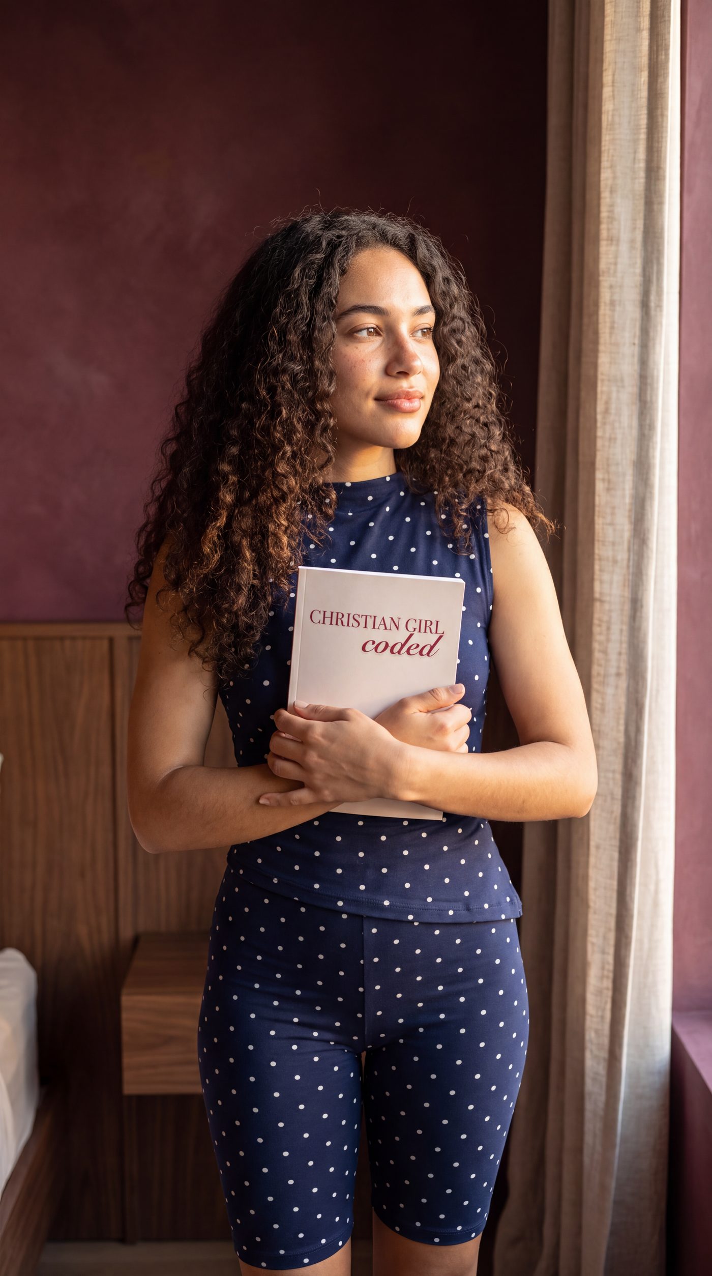 Christian Girl Coded held against an oxblood wall