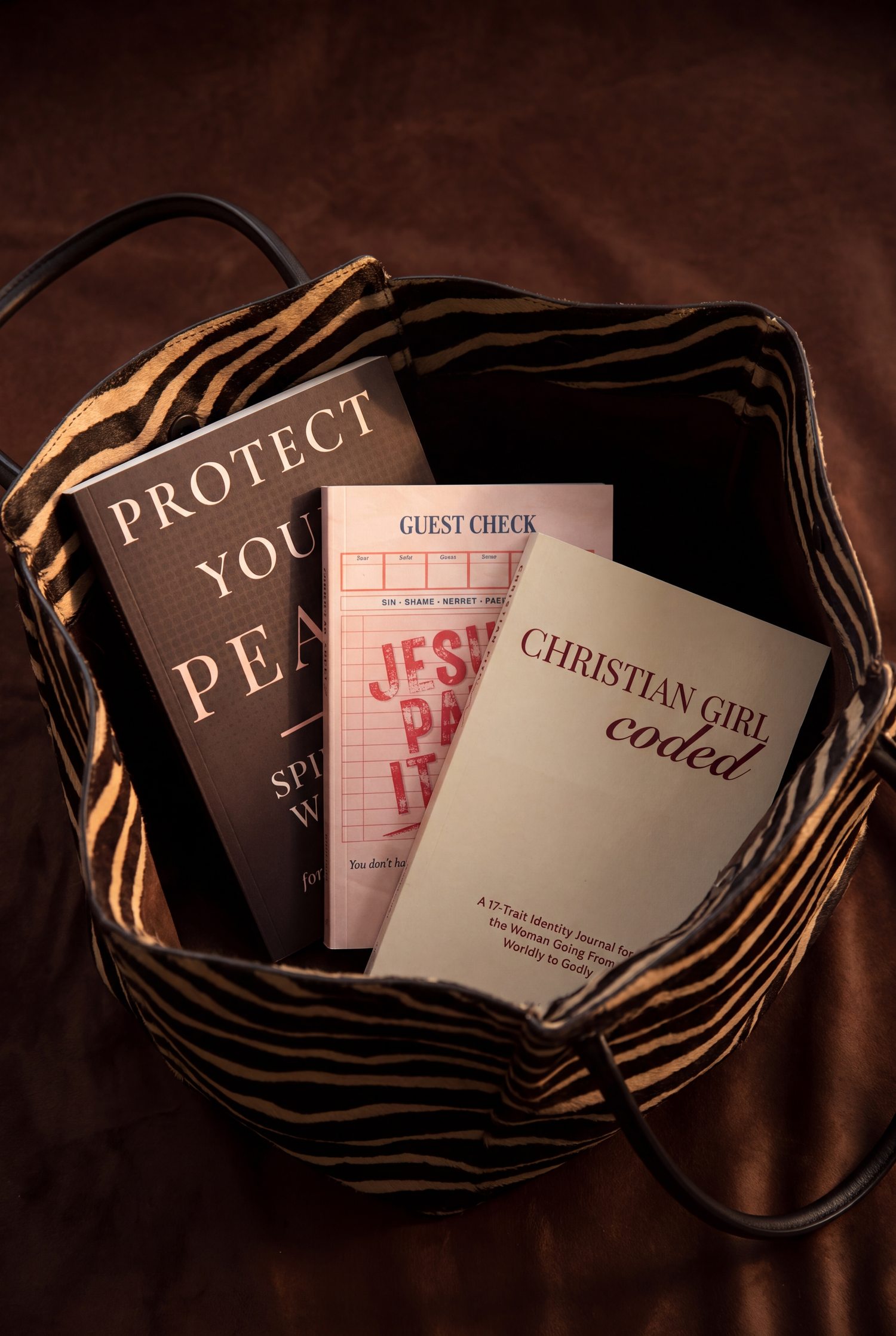 All three Worthy Word Co. books in an animal print leather tote